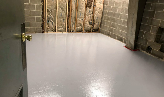 This image shows a basement floor with a gray epoxy floor.