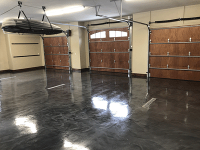 This image shows an garage with metallic epoxy floor. It has a combination of gray and black metallic epoxy.