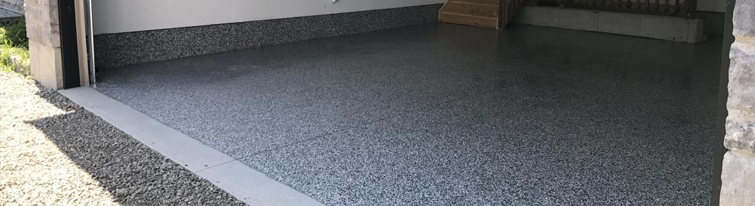 This image shows an garage with a flake epoxy floor.